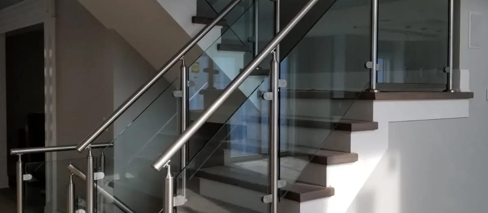 Elegant glass railing with a wooden handrail by Zenith Glass and Mirror, merging modern and traditional styles.